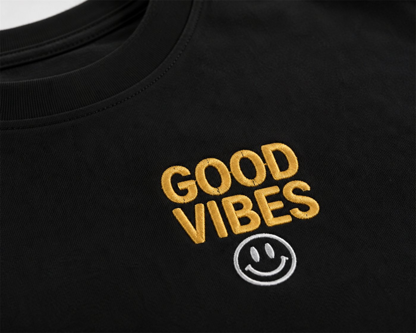 Zlato izvezen napis »Good Vibes« s smeškom na črni majici
